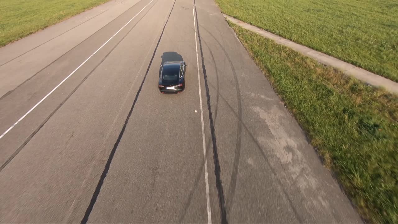 A drone shot of an electromobile speed driving on the airway