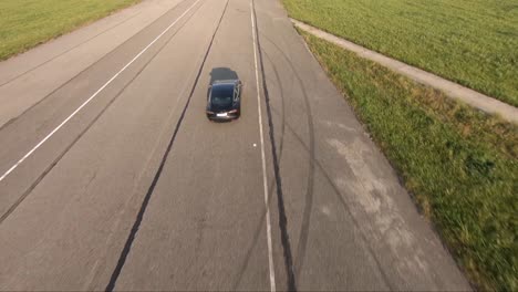 a drone shot of an electromobile speed driving on the airway