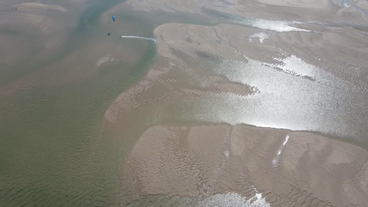 An athlete doing windsurfing on a river estuary in Portugal. Sot