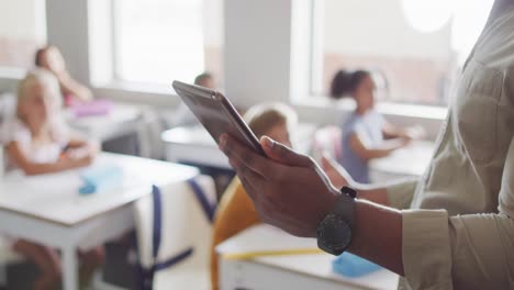 Video-of-hands-of-african-american-male-teacher-with-tablet-during-lesson