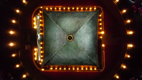 Drone-view-over-Bell-Tower-roof-at-night-with-traffic-circling-below