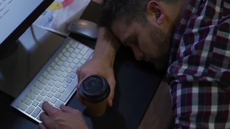 hombre de negocios durmiendo en una oficina moderna por la noche