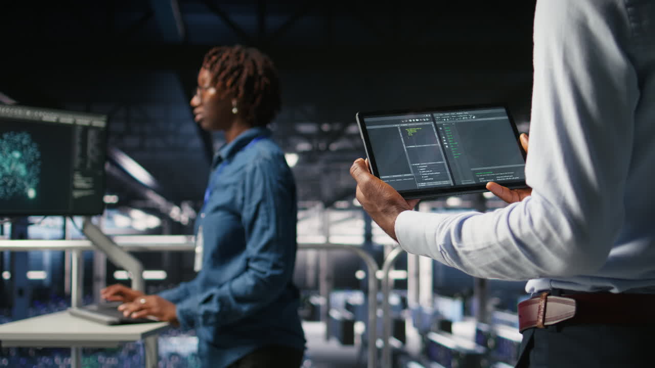 Close up of data center programmer looking at code debugging tools on tablet