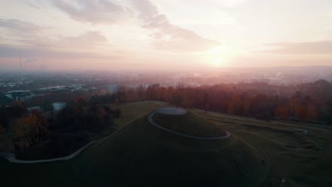 aerial shot of football player juggling a soccer ball on the mound at early sunrise