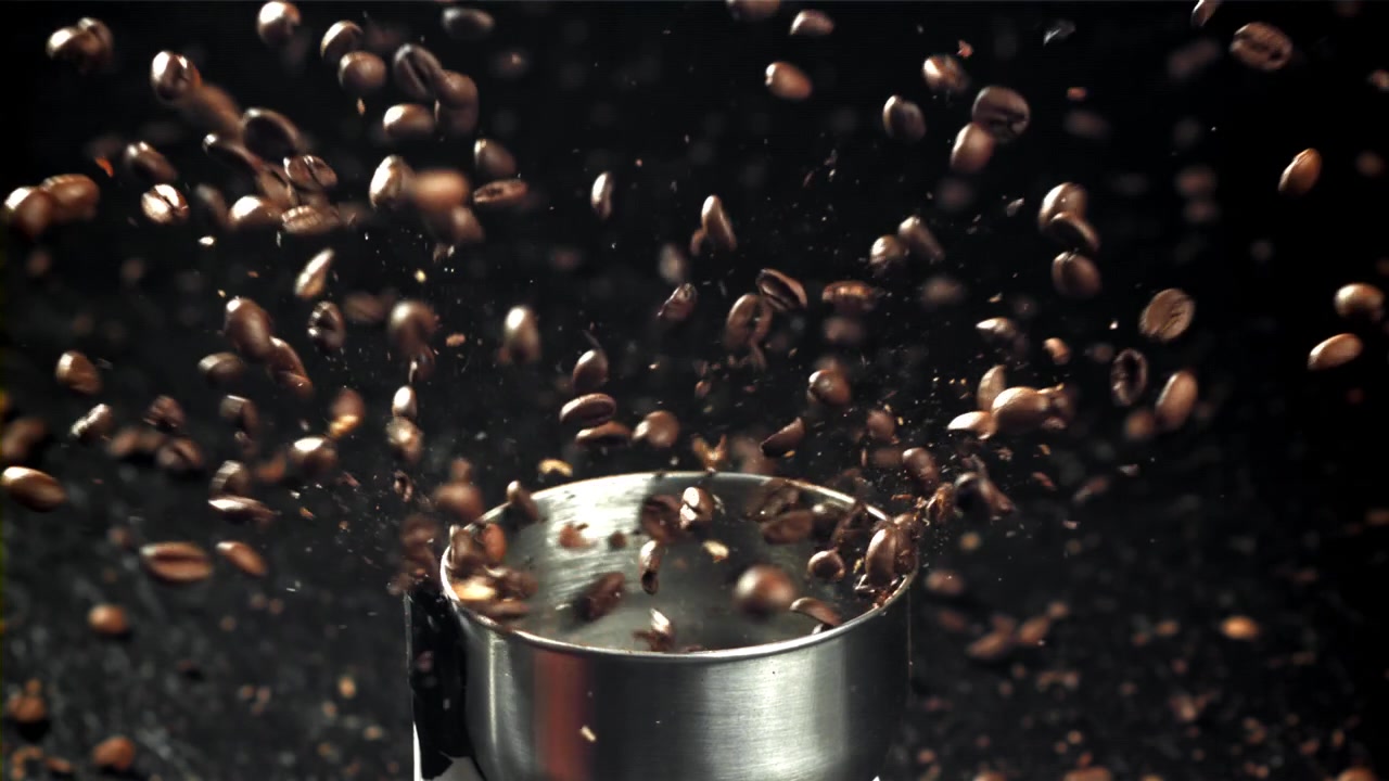 Slowmotion af kaffebønner der males i en kaffekværn
