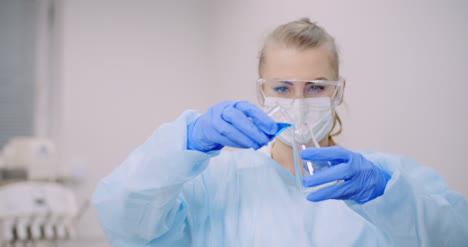 Female-Scientist-Holding-Tubes-And-Flask-With-Liquid-In-Hands-7