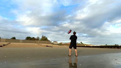 man flying a power kite on the beach
