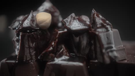 hazelnuts falling on dark chocolate pieces with syrup