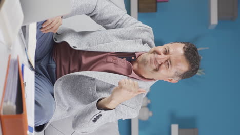 Vertical-video-of-Home-office-worker-old-man-experiencing-joy-looking-at-camera.