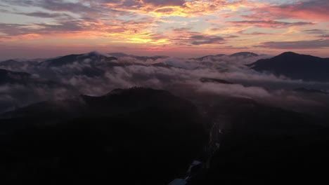 a drone flying over the clouds at dawn