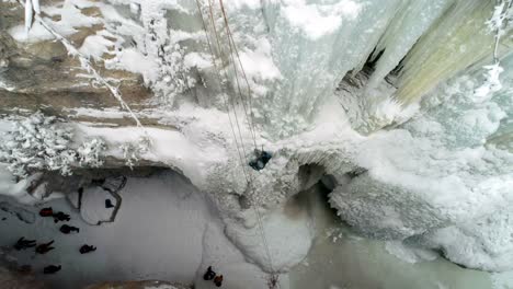 ice climber climbing frozen cliff during winter 4k