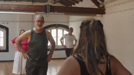 long shot of senior people learning to move hips in dance class