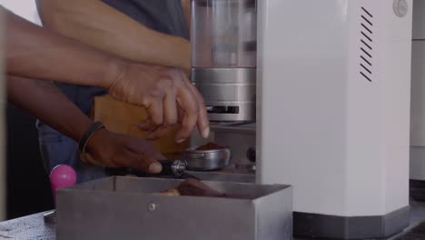 african barista cleaning coffe machine and making freshly brewed coffee at a street food market in hermanus in south africa.