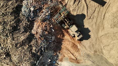 loader piling sawdust at recycling area of wood in canada