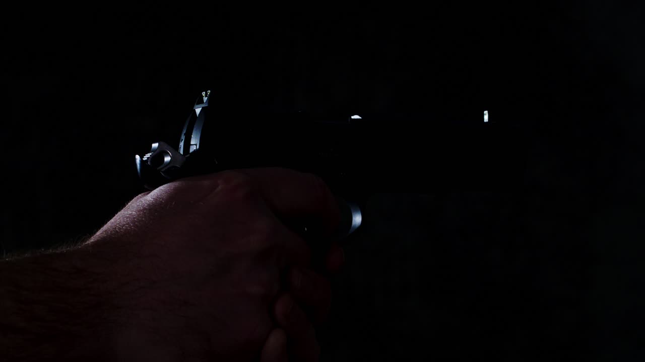 disparar lentamente disparando una pistola en un cuarto oscuro hasta que esté vacío