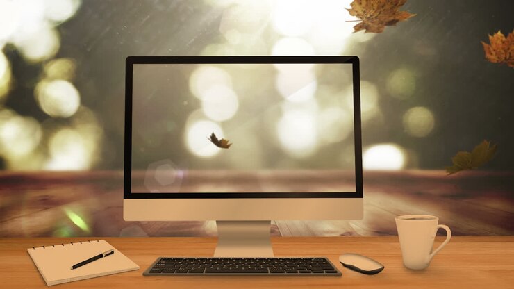 Animation von fallenden Blättern über Laptop, Computer und Schreibtisch.