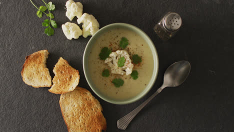 video of cauliflower soup and ingredients lying on grey surface