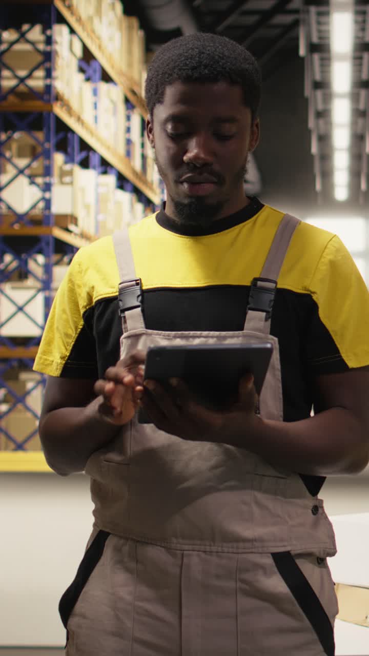 Video verticale: Lavoratore e-commerce afroamericano che filma un video promozionale all'interno di un centro di evasione ordini.