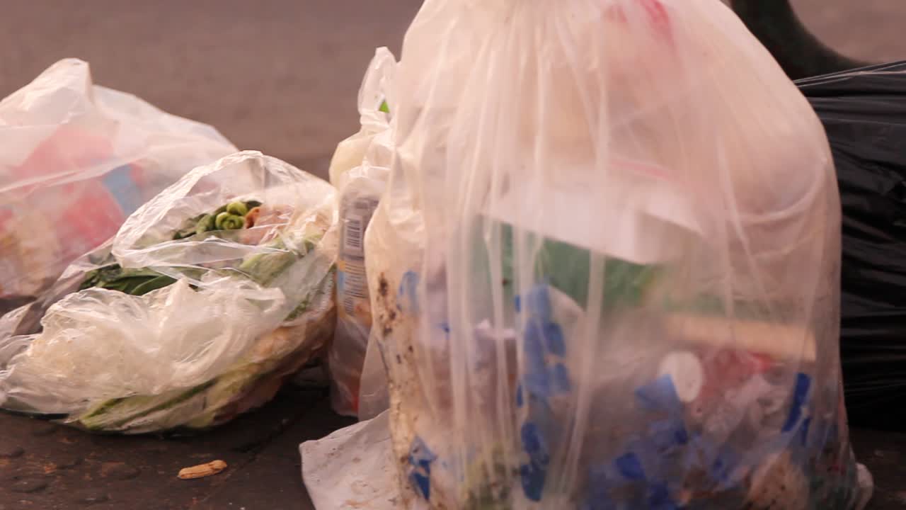 bolsas de basura dejadas en la calle por la mañana, panorámica a la derecha