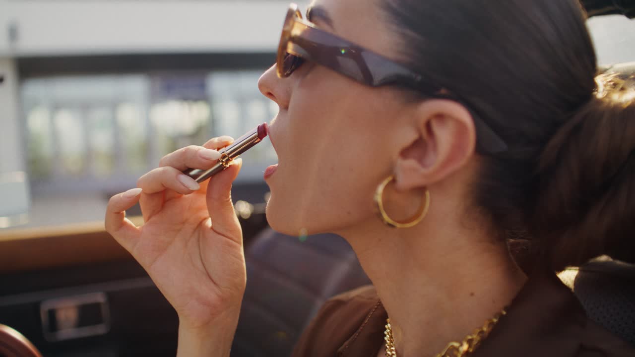 mujer aplicando lápiz labial en un coche