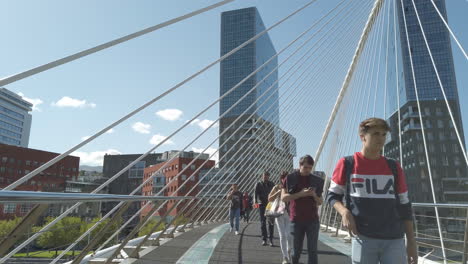 people walking on a modern bridge in a city