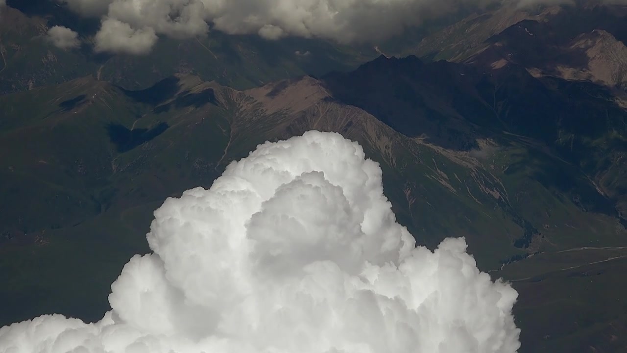 山脈の上空に広がる大きな白い積雲の空撮