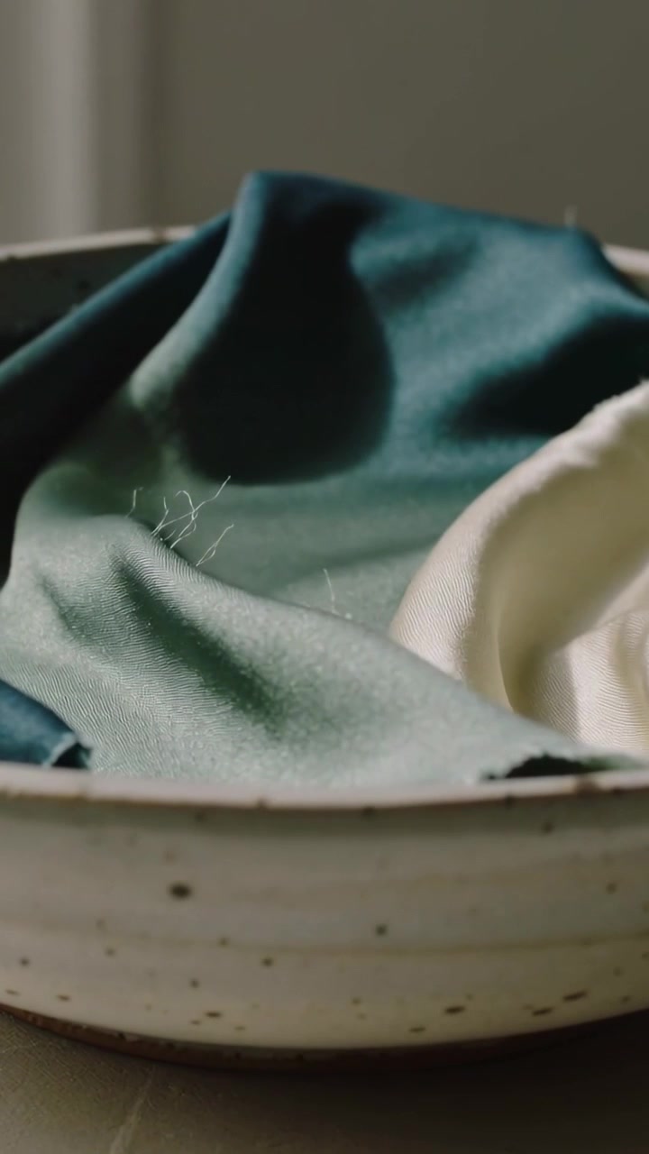 Vertical video: Tilting camera showing teal, cream napkins in bowl at home to show texture, lint