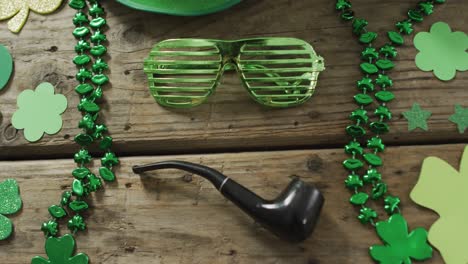 나무 테이블에 복사 공간을 가진 파이프와 함께 shamrocks 및 유리