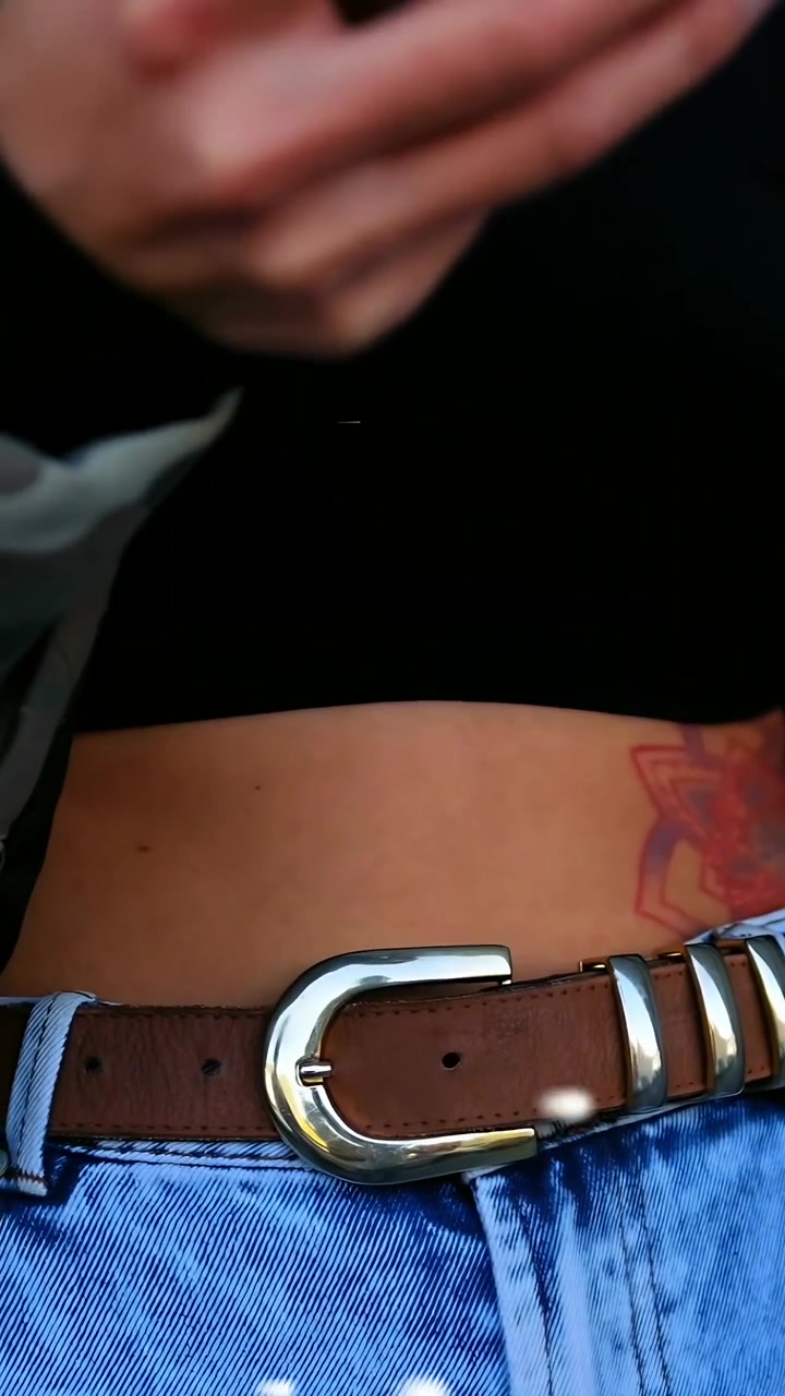 Video vertical: Mano interactuando con un teléfono, mujer levantando y deslizando, efecto bokeh enmarcando el teléfono para tecnología.