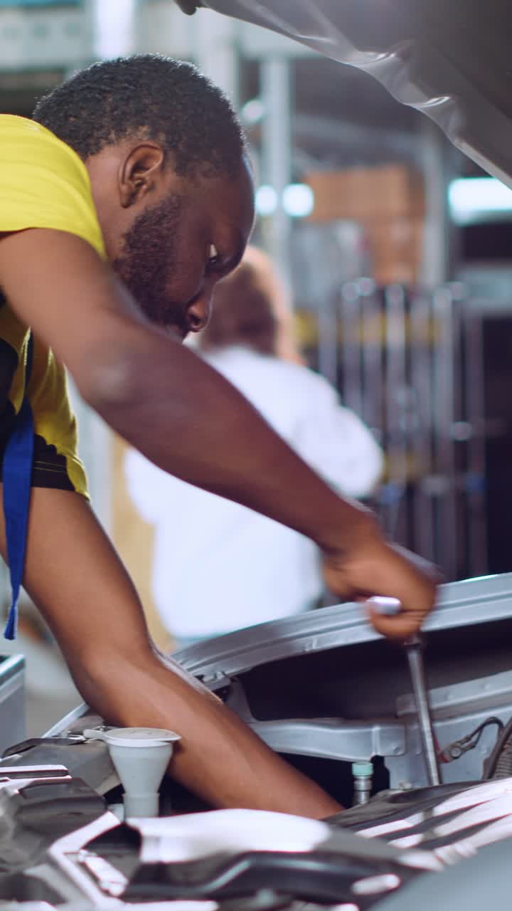 Vertical video Professional in car service uses wrench