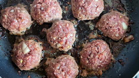 frying meat balls on non-stick pan with oil