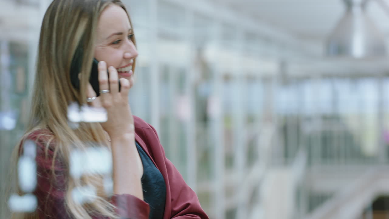donna d'affari che usa uno smartphone che fa una telefonata chattando al cellulare che si gode la conversazione con un cliente al lavoro in ufficio