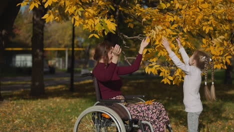 Woman-with-injury-and-preschooler-girl-enjoy-autumn-nature