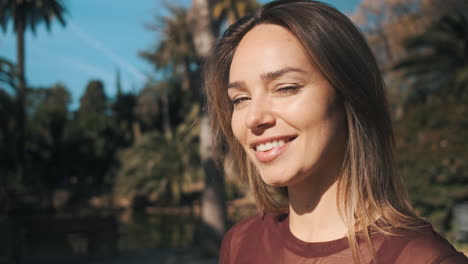 mujer rubia encantadora con ojos azules mirando juguetón a la cámara.