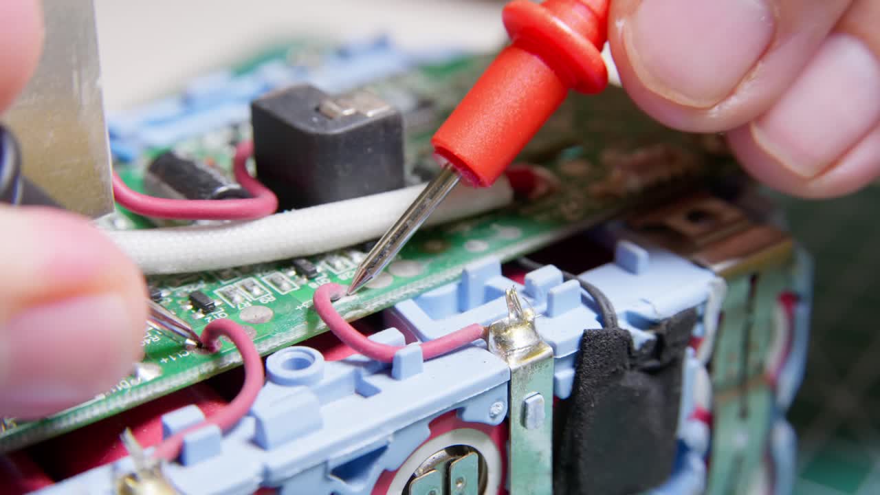 Close up fault finding an electrical battery unit with a multimeter. Clip 2