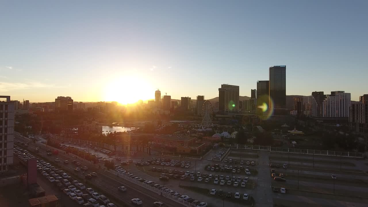 Filmagem aérea de drone sobre o trânsito e edifícios ao pôr do sol em Ulaanbaatar, Mongólia.