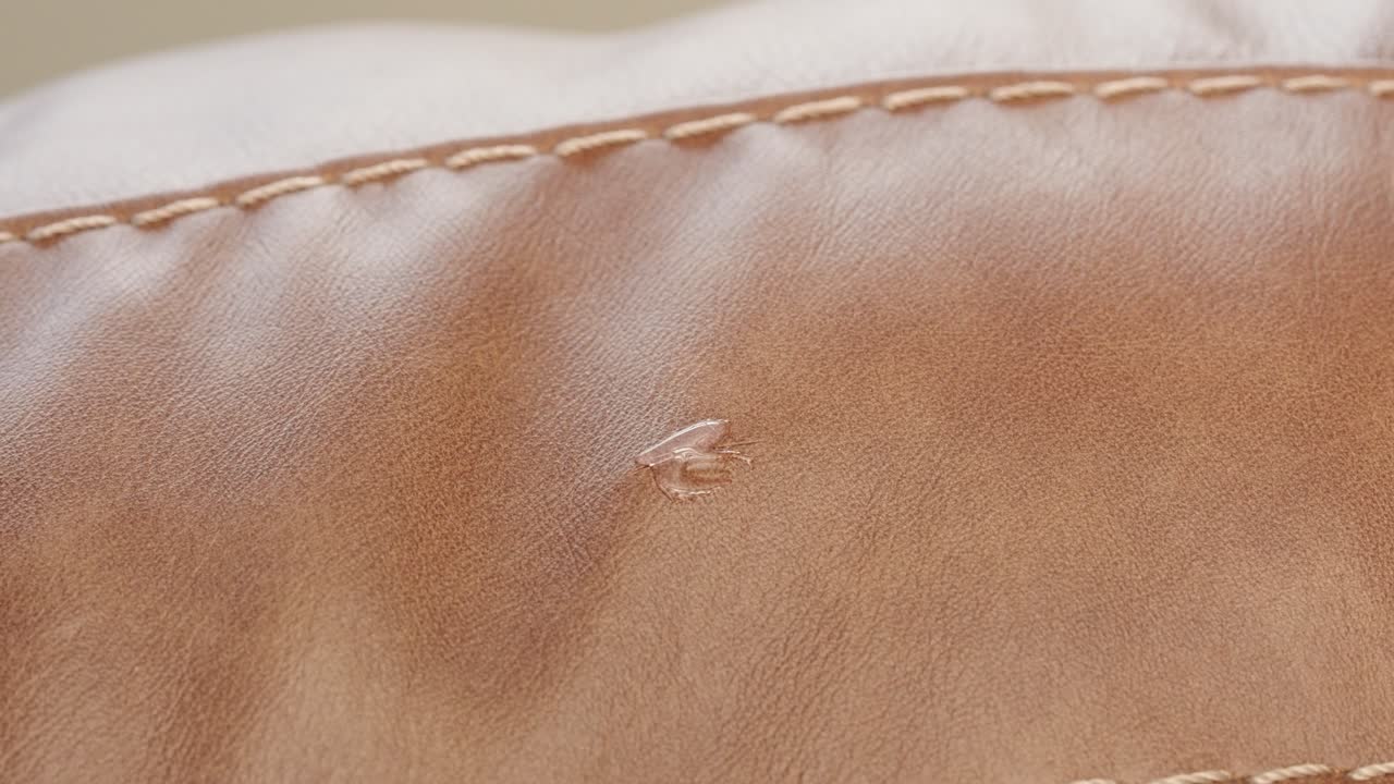 Glue bonds cut while heat gun cures and cloth smooths repair on brown leather