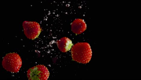strawberries falling into water super slowmotion, black background, lots of air bubbles, 4k240fps