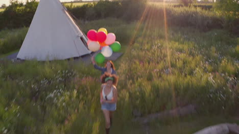 drone disparó a dos amigas acampando en un festival de música corriendo por el campo con globos