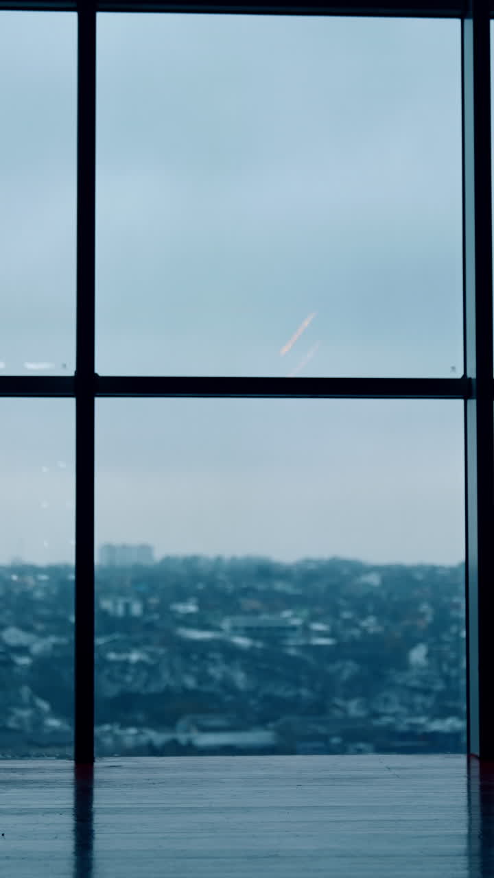 Silhouettes of male and female workers approaching each other. Man drinks coffee and woman speaks on the phone. Panoramic window at backdrop. Vertical video