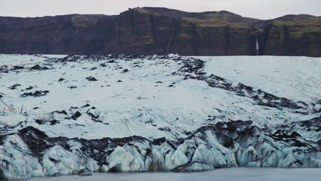 hikers appear tiny as they explore a vast glacier, navigating the frozen terrain