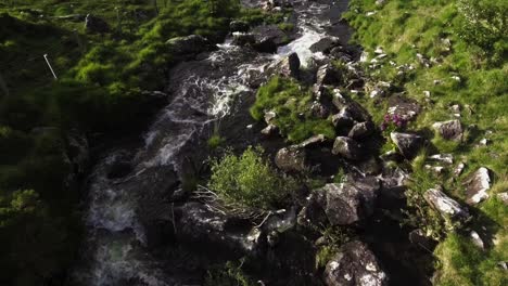 Aerial-drone-shot-of-small-river,-cliffs,-mountains,-and-nature-in-Ireland