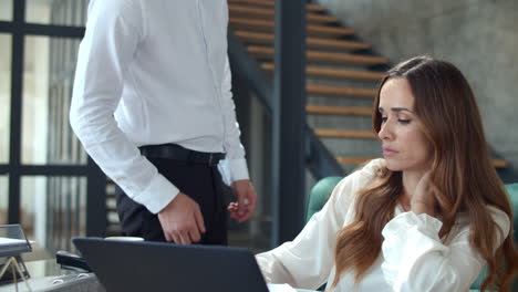 angry boss throwing papers in front of secretary