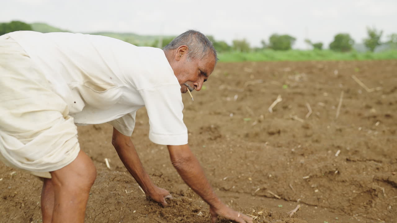 A farmer smoking tobacco in a field