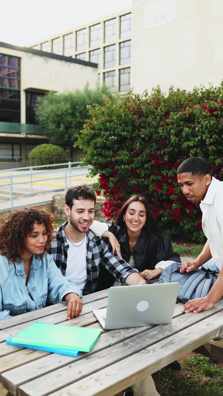 Giovani studenti felici che usano il laptop all'aperto nel campus