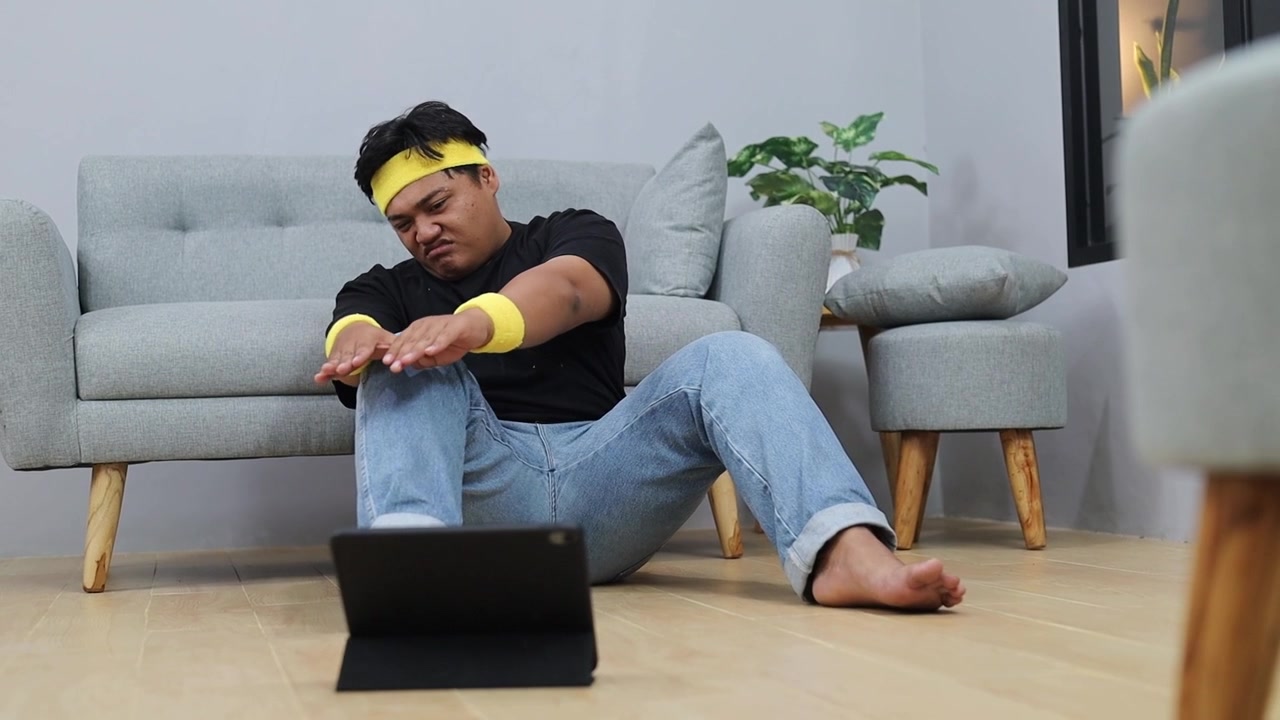 Lat asiatisk overvektig mann som trener hjemme