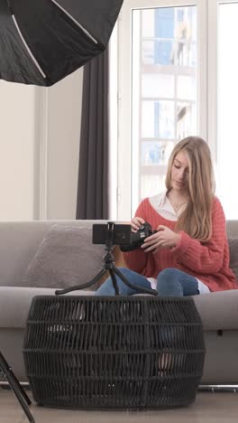young woman talking on mobile camera, explaining a photo camera. content creator concept