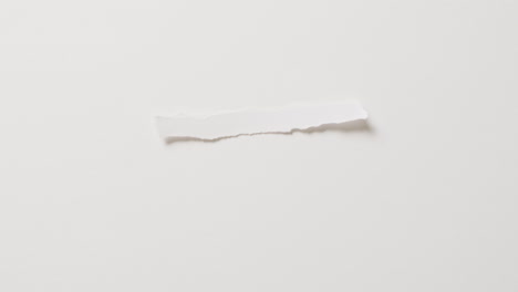 Video-of-close-up-of-torn-piece-of-paper-with-copy-space-on-white-background