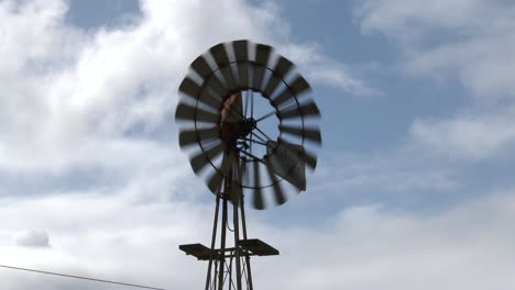 Close-up-of-a-wind-pumps-blades-rotating-with-a-background-of-moving-clouds