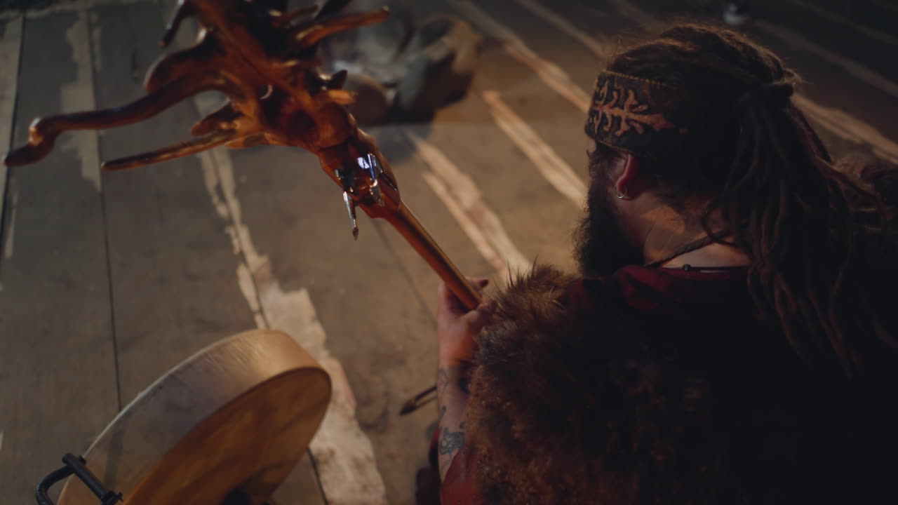 hombre de piel toca un elegante instrumento de cuerda en un escenario rústico